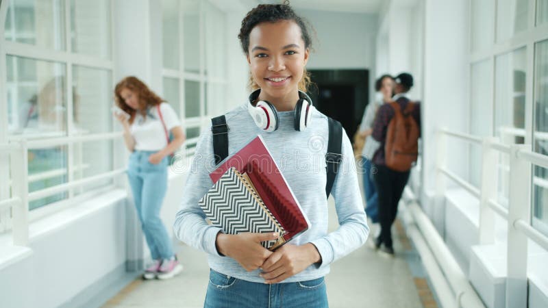 Joyful blandade racetunga som håller böcker i college som leker arkivfilmer