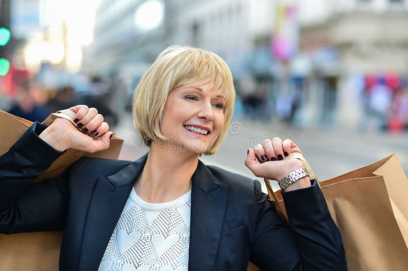 Joyful businesswoman holding shopping bags