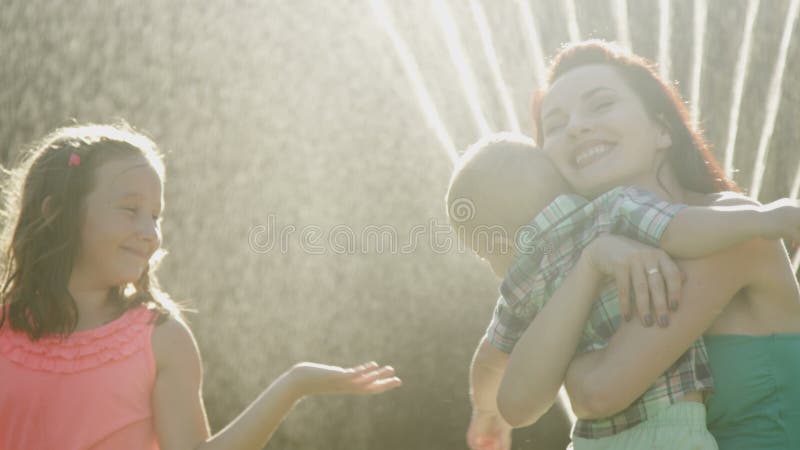 Joyful Family in the Backyard Mother hugging Child Smiling with Sunshine