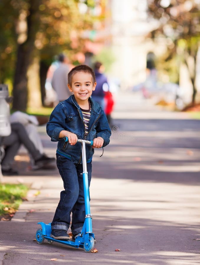 Joyful kid riding a scooter