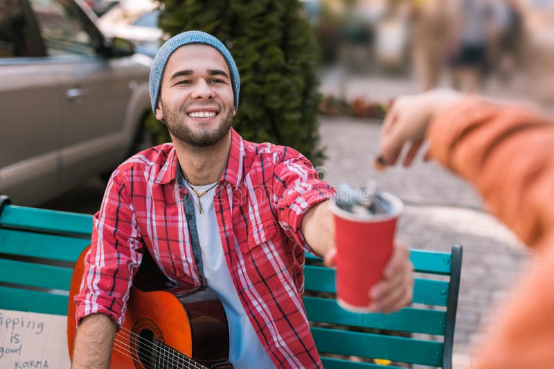 Joyful male guitarist gathering money for play royalty free stock photo Joyful male guitarist gathering money for play royalty free stock photo