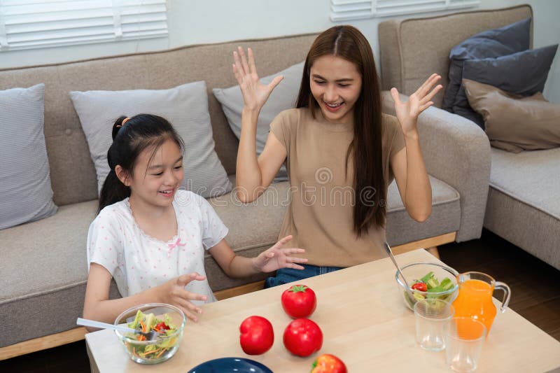 Wellness through healthy eating: Mother and daughter enjoying meals together stock images
