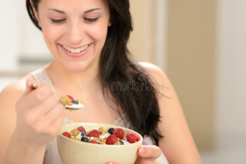 Joyful woman eating healthy cereal stock photography