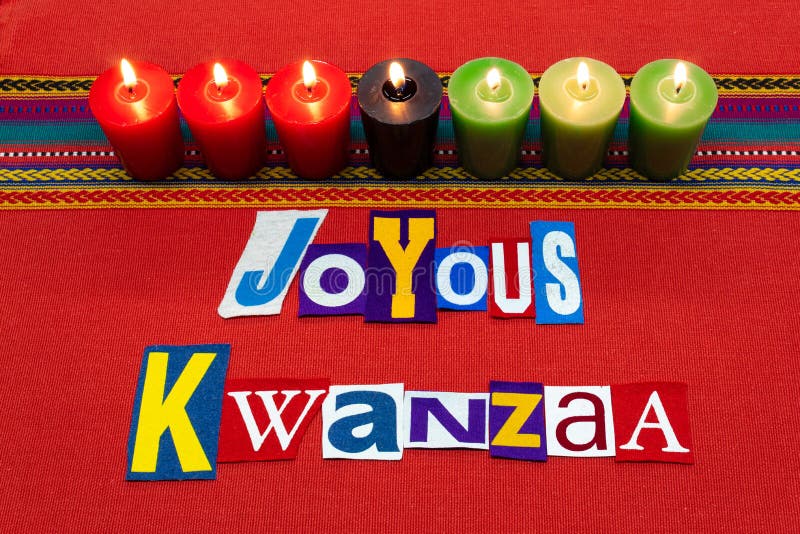 JOYOUS KWANZAA text word collage typography, with seven candles and multi colored fabric on red woven fabric, African American hol. Iday, horizontal aspect royalty free stock photo