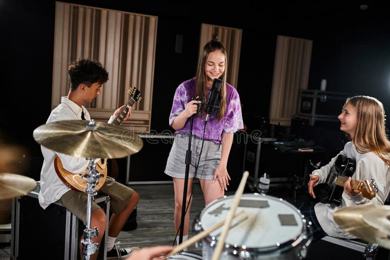 joyous talented teenage band members in casual attires singing and playing various instruments, stock photo. joyous talented teenage band members in casual attires singing and playing various instruments, stock photo