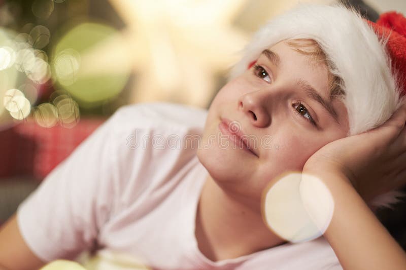 Jristmas porträtt av pojke mot bakgrund av julgransträd med ljus. festlig glädje och mirakel. Julklapp av en pojke mot bakgrund av ett julgransträd med ljus. festlig glädje och förväntan på ett mirakel