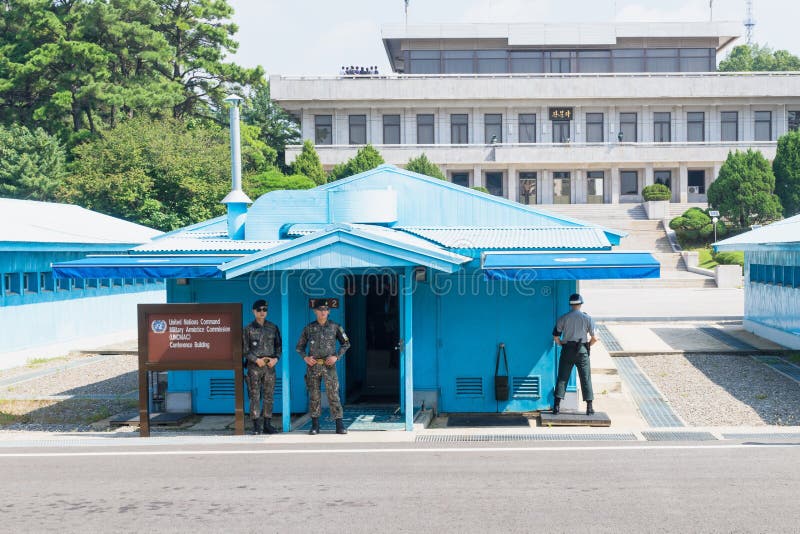 JSA binnen DMZ, Korea - September 8 2017: De V.N.-militairen en militairen in camoulagekleren voor blauwe gebouwen bij Noord-zuid stock fotografie JSA binnen DMZ, Korea - September 8 2017: De V.N.-militairen en militairen in camoulagekleren voor blauwe gebouwen bij Noord-zuid stock fotografie