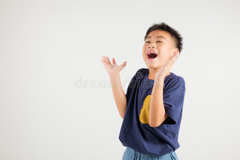 A jubilant kid boy raises her fists in celebration of her success, saying yes stock photo