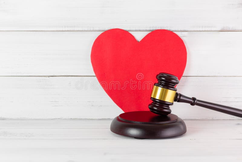 Judge Gavel Hammer with Red Heart on white wood background. Family or Love of Law Concept with Copy Space