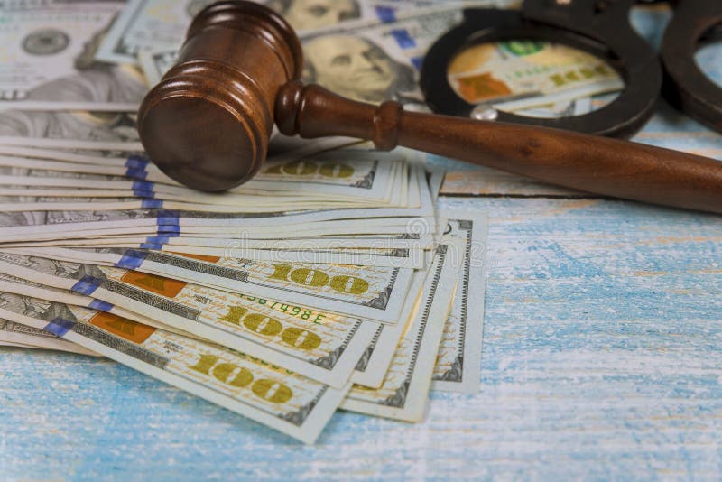 Judge hammer gavel with handcuffs in the dollar bills stock photos Judge hammer gavel with handcuffs in the dollar bills stock photos