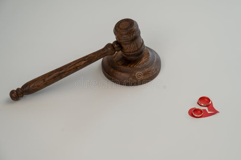 Judicial gavel broken heart and wedding rings.