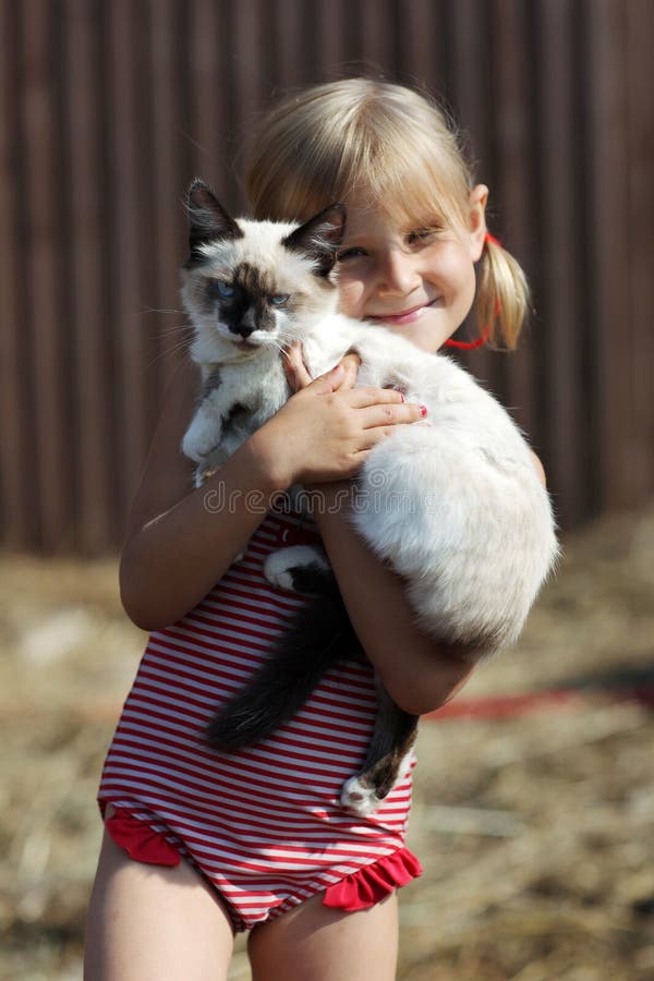 Plays a girl and with a cat in nature. Plays a girl and with a cat in nature