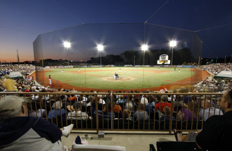 People watching a baseball game at a stadium. People watching a baseball game at a stadium