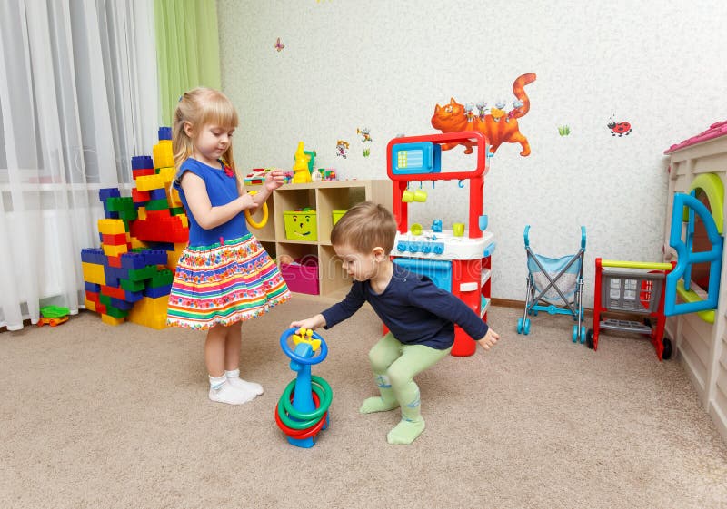 Juego de dos niños con los anillos plásticos en guardería imágenes de archivo libres de regalías Juego de dos niños con los anillos plásticos en guardería imágenes de archivo libres de regalías