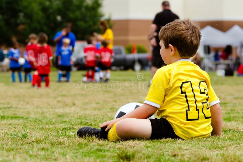 Juego de fútbol de observación de la juventud del niño imagenes de archivo