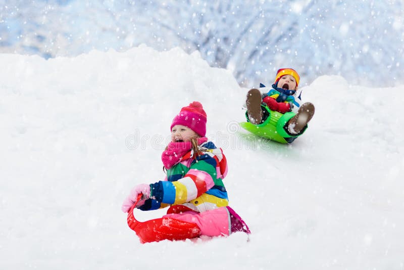Juego de los niños en nieve Paseo del trineo del invierno para los niños