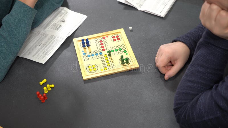 Juego de mesa Ludo. Manos de los jugadores. Tiempo de familia almacen de video