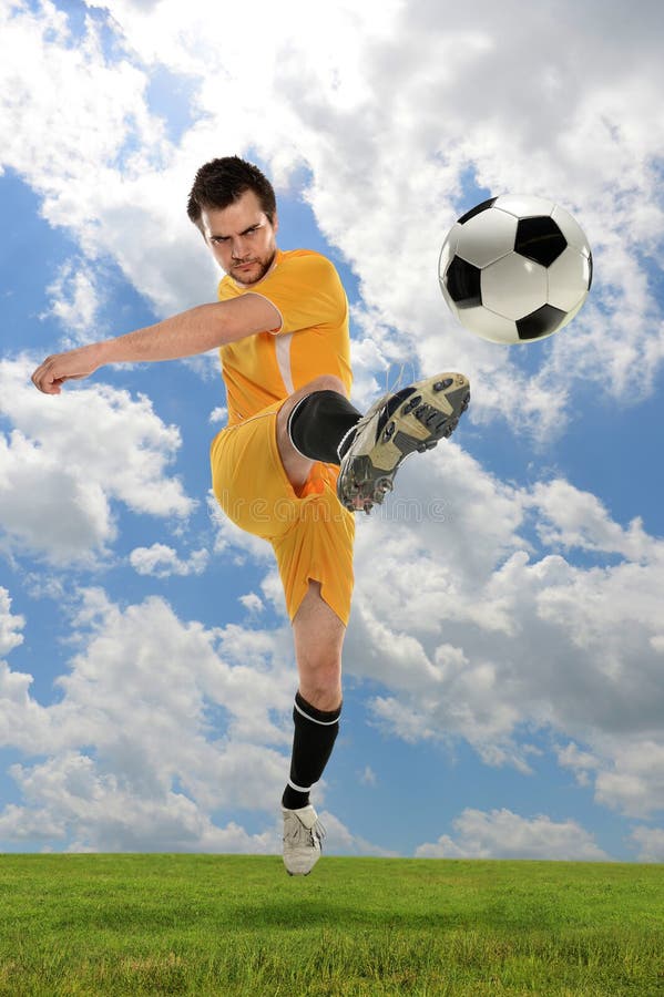 Jugador de fútbol que golpea la bola con el pie fotografía de archivo libre de regalías Jugador de fútbol que golpea la bola con el pie fotografía de archivo libre de regalías