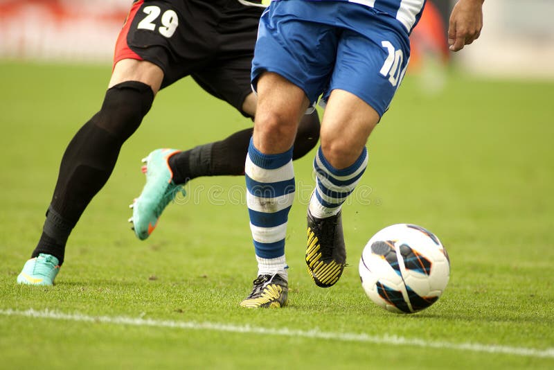 Jugador de fútbol que protege una bola imagen de archivo
