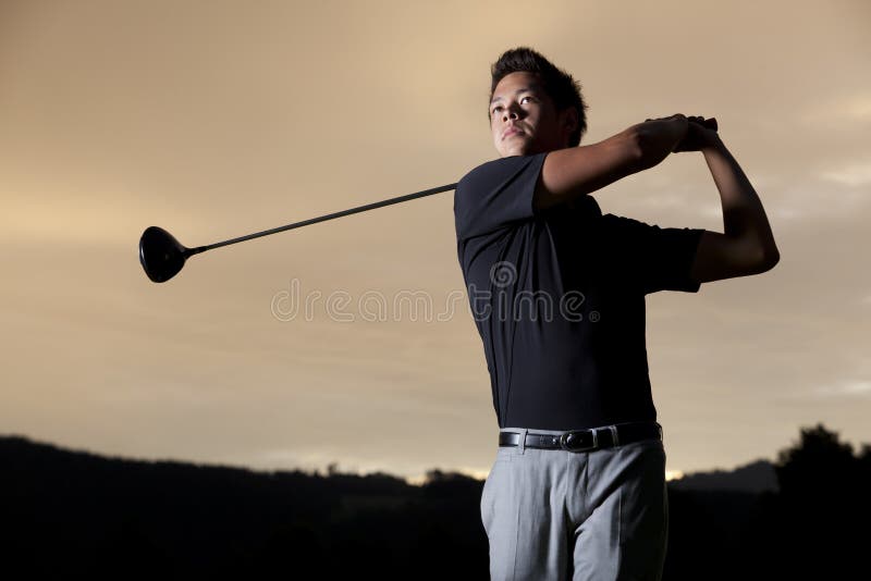 Jugador de golf que junta con te apagado en la puesta del sol. foto de archivo Jugador de golf que junta con te apagado en la puesta del sol. foto de archivo