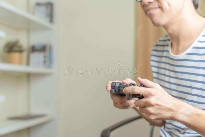 Jugador jugando videoconsola o juego en línea por manos de un joven adulto o adolescente que utilice el controlador de juegos para imágenes de archivo libres de regalías