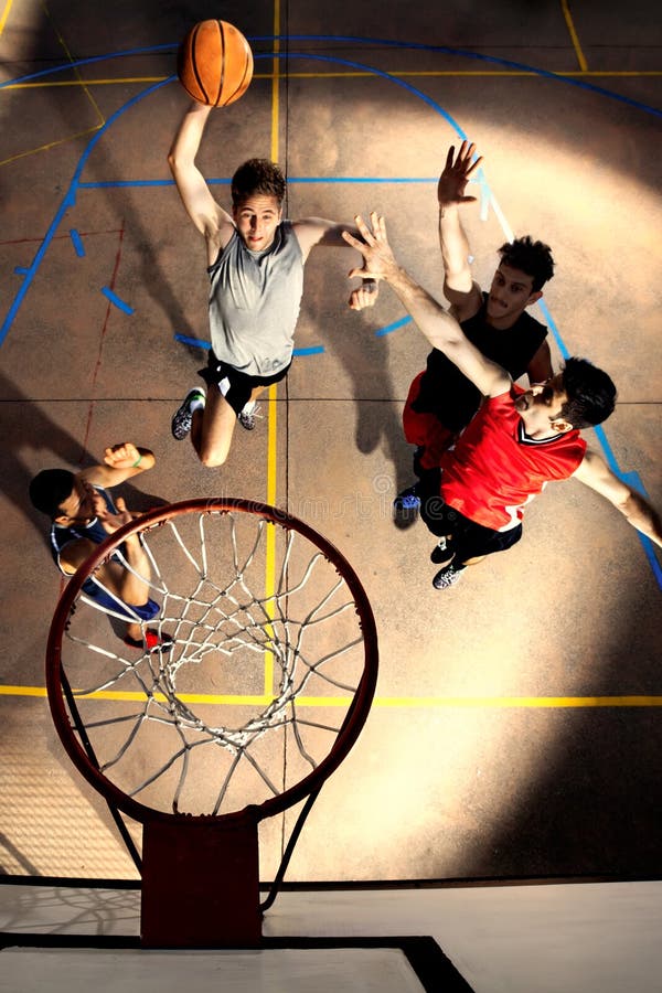 Jugadores de básquet jovenes que juegan con energía y poder