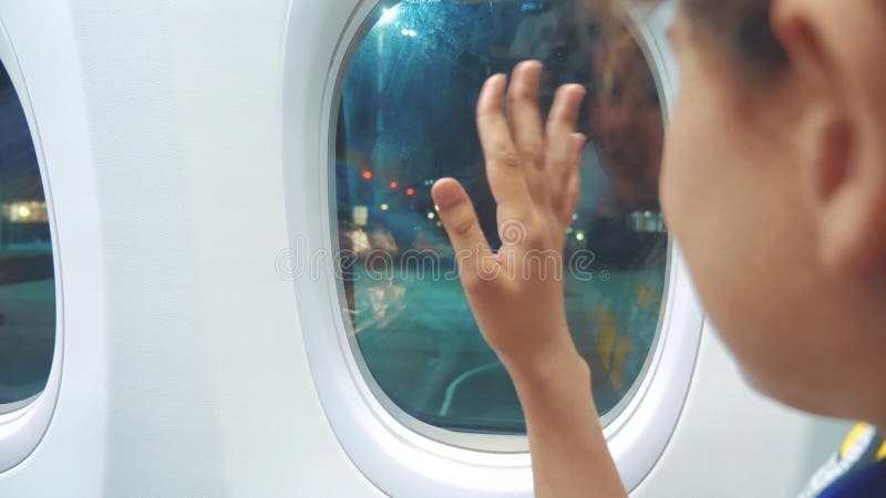 Jugendlich Mädchen nimmt Abschied, seine Hand am Fenster des flachen Lebensstilluftfahrt-Flugzeugkonzeptes wellenartig bewegend B stock footage
