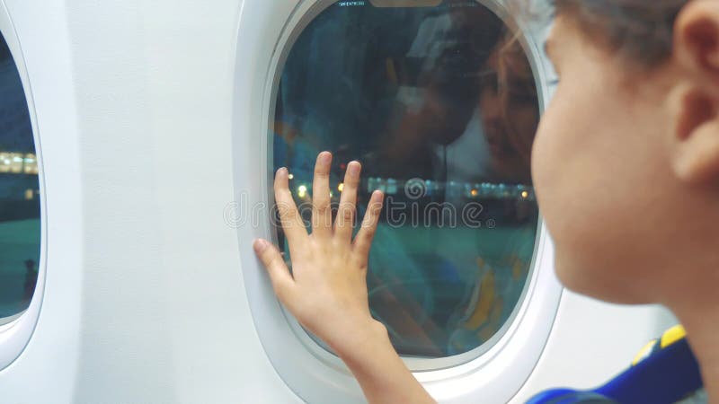 Jugendlich Mädchen nimmt Abschied, seine Hand am Fenster des flachen Luftfahrtflugzeug-Konzeptlebensstils wellenartig bewegend Bl stock video footage