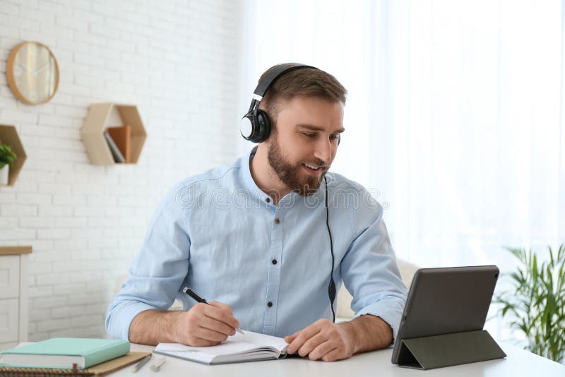 Jugendliche, die sich während des Online-Webinars an Tischen im Innenbereich Notizen machen lizenzfreies stockbild