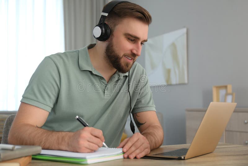 Jugendliche, die sich während des Online-Webinars an Tischen im Innenbereich Notizen machen lizenzfreies stockfoto