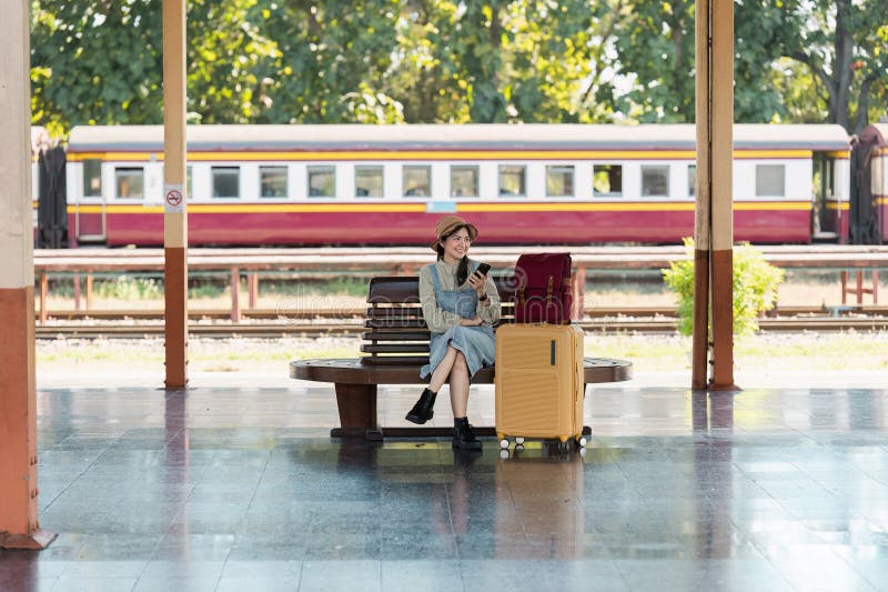 Jugendliche warten am Bahnhof mit Gepäck und Smartphone auf ihr Abenteuer stockfoto