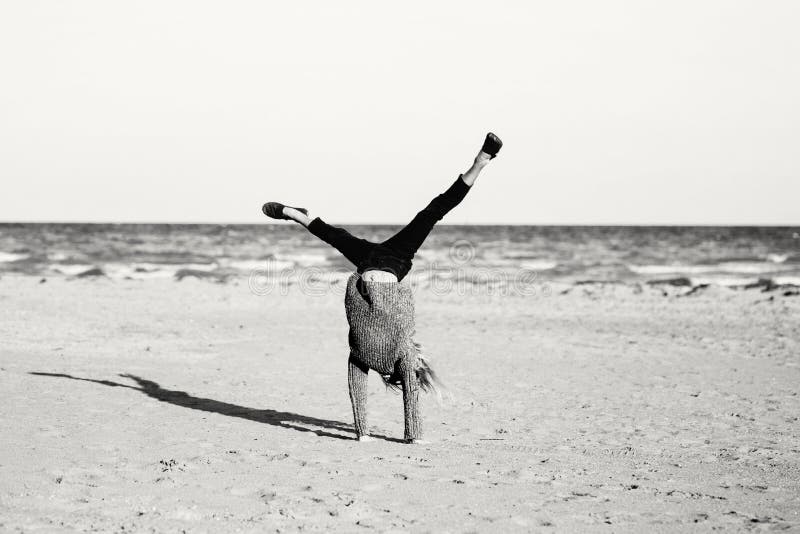 Jugendlicher, der das Wagenrad spielt auf Strand tut lizenzfreies stockbild Jugendlicher, der das Wagenrad spielt auf Strand tut lizenzfreies stockbild