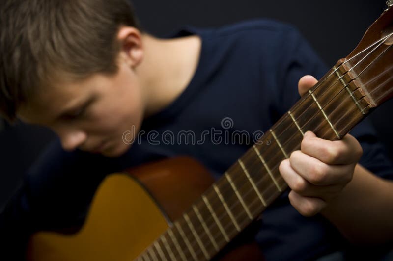 Teenager beim Gitarrespielen lizenzfreie stockbilder