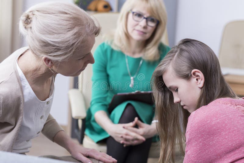 Teenage girl with mother at psychological consultation with professional therapist in mental healthcare clinic. Teenage girl with mother at psychological consultation with professional therapist in mental healthcare clinic