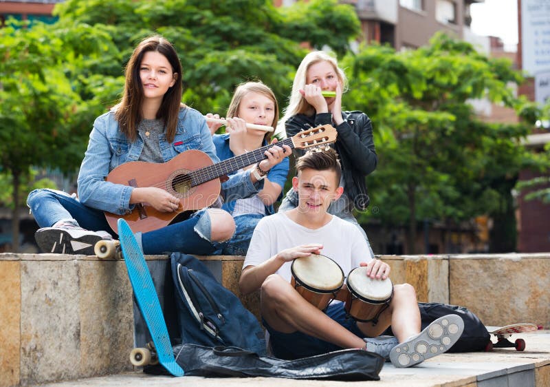 Jugendlichfreunde, die Musikinstrumente spielen stockbild Jugendlichfreunde, die Musikinstrumente spielen stockbild