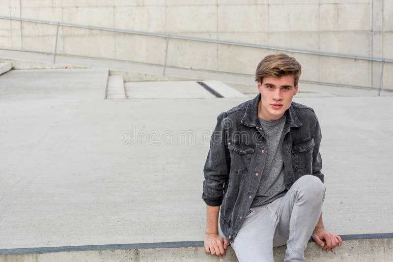 Jugendlichjunge, der auf der Treppe glücklich sitzt lizenzfreie stockfotos Jugendlichjunge, der auf der Treppe glücklich sitzt lizenzfreie stockfotos