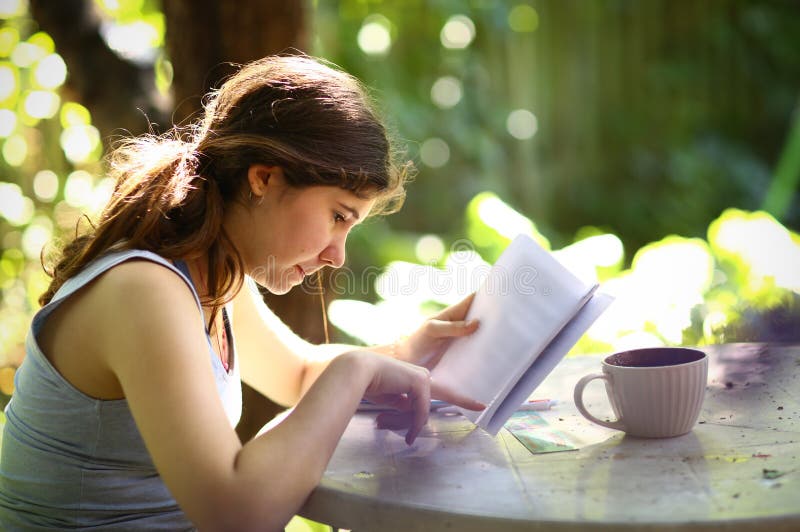 Jugendlichstudentenmädchen-Lesebuch mit Teeschale stockbild Jugendlichstudentenmädchen-Lesebuch mit Teeschale stockbild