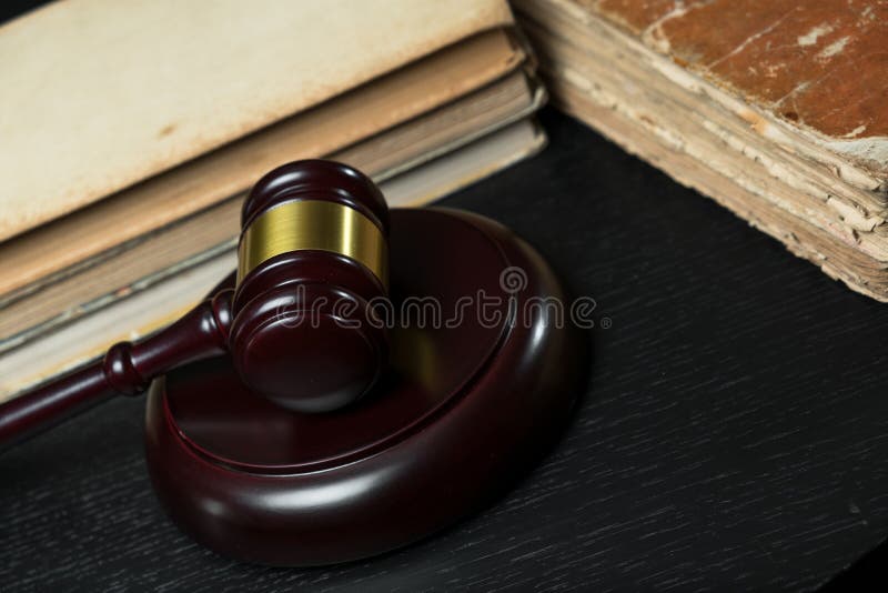 Jugez le marteau près de la pile des livres sur le fond en bois images libres de droits Jugez le marteau près de la pile des livres sur le fond en bois images libres de droits