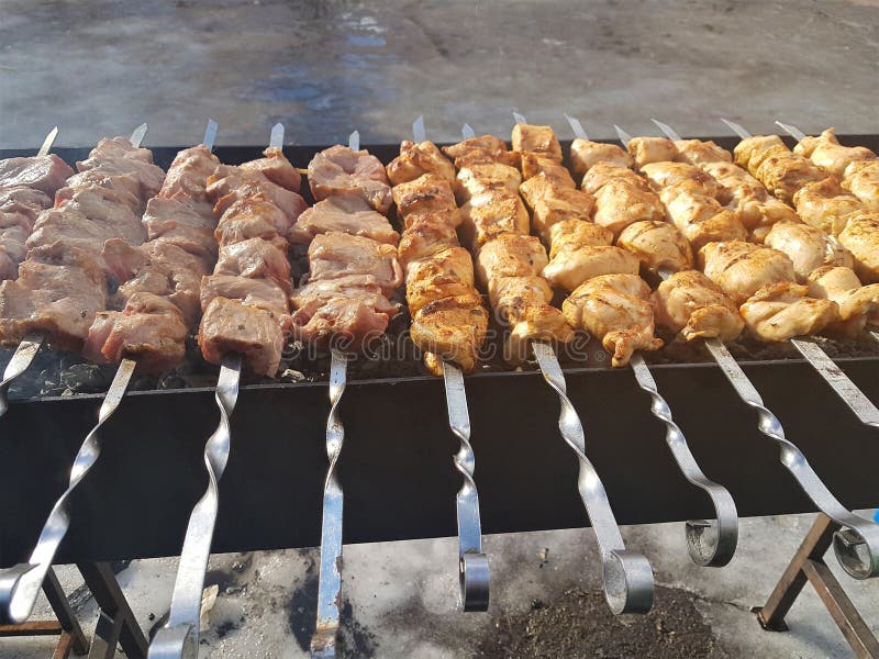 Jugoso adobado en kebab de la carne de las especias en los pinchos, cocinado y frito en una parrilla de la barbacoa del fuego y d fotos de archivo Jugoso adobado en kebab de la carne de las especias en los pinchos, cocinado y frito en una parrilla de la barbacoa del fuego y d fotos de archivo