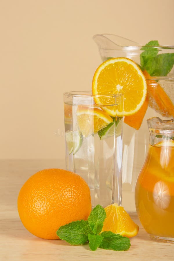Jugs with drinks, oranges and spearmint