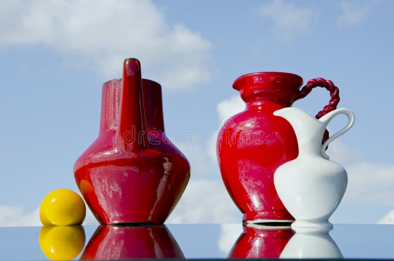 Jugs and yellow ball on mirror