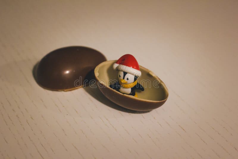 Juguete del pingüino en el huevo de chocolate Niñez en mi corazón kinder sorpresa imagen de archivo libre de regalías Juguete del pingüino en el huevo de chocolate Niñez en mi corazón kinder sorpresa imagen de archivo libre de regalías
