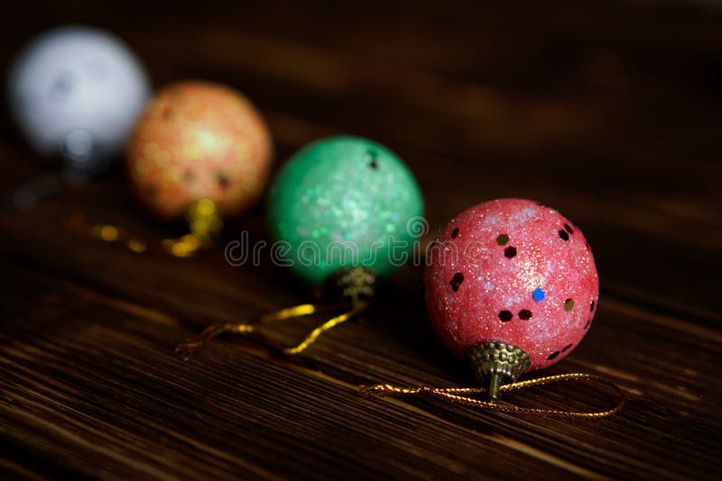 Juguetes de la Navidad - cuatro bolas multicoloras en una oscuridad imagen de archivo Juguetes de la Navidad - cuatro bolas multicoloras en una oscuridad imagen de archivo
