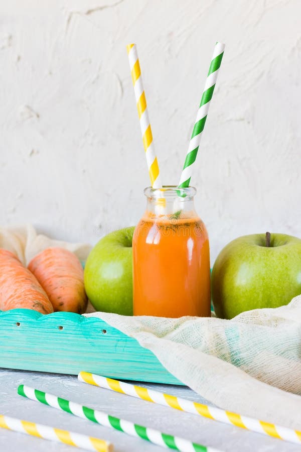 Juice from apples and carrots in a glass bottle