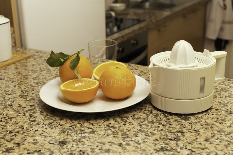 Juicer with Freshly Squeezed Orange Juice and Whole and Sliced Oranges