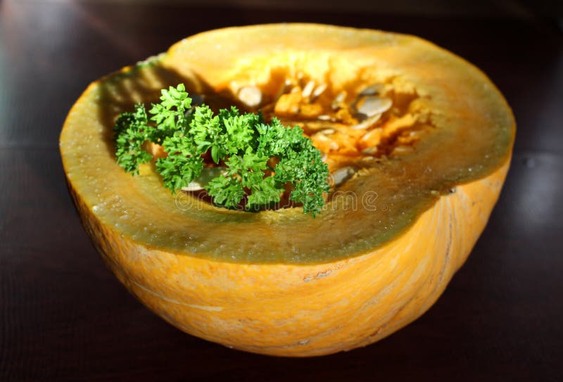 Juicy fresh yellow pumpkin half cut with bright green seasoning parsley still life royalty free stock image Juicy fresh yellow pumpkin half cut with bright green seasoning parsley still life royalty free stock image