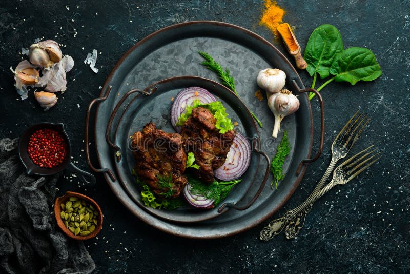 Juicy fried pork steak with spices on a black stone plate. Top view. Free copy space. Pork view stock images, royalty-free photos and pictures