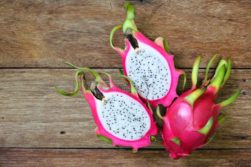 Juicy pink pitaya on wooden table