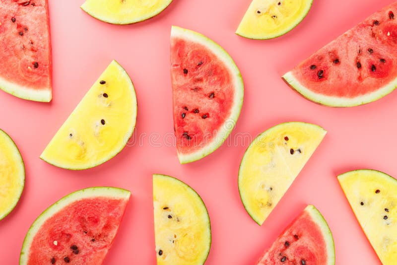 Juicy slices of red and yellow watermelon on a bright pink background. Conceptual colors of summer. Patterns top view as a