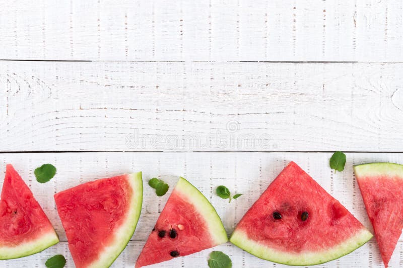 Juicy slices of a ripe watermelon on a white wooden background. Berry food background royalty free stock image Juicy slices of a ripe watermelon on a white wooden background. Berry food background royalty free stock image